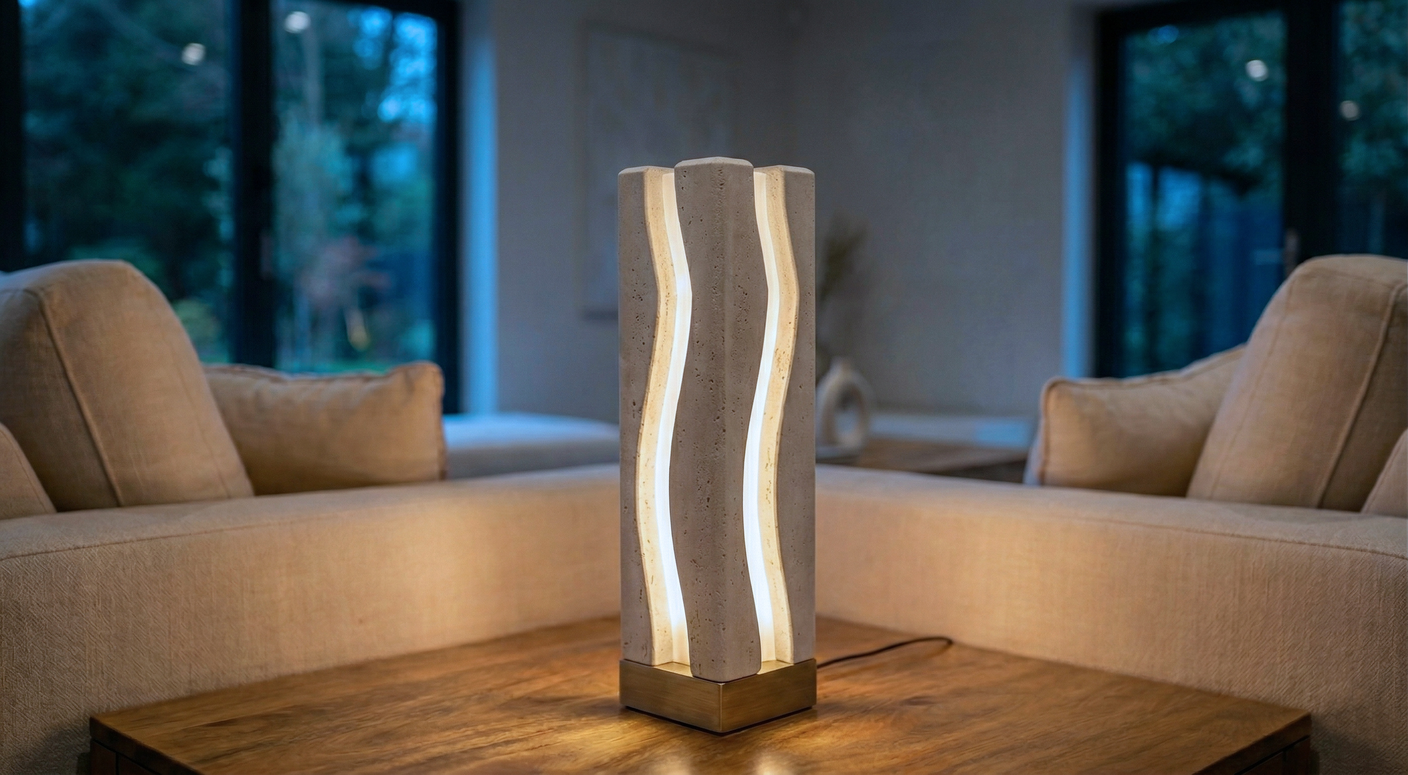A modern lifestyle shot of the Ora Light Pillar by Teroli Design in Sydney, Australia. The wave-form mineral composite light illuminates a warm wooden surface between minimalist neutral sofas, creating a restorative ambient glow in a contemporary living sp