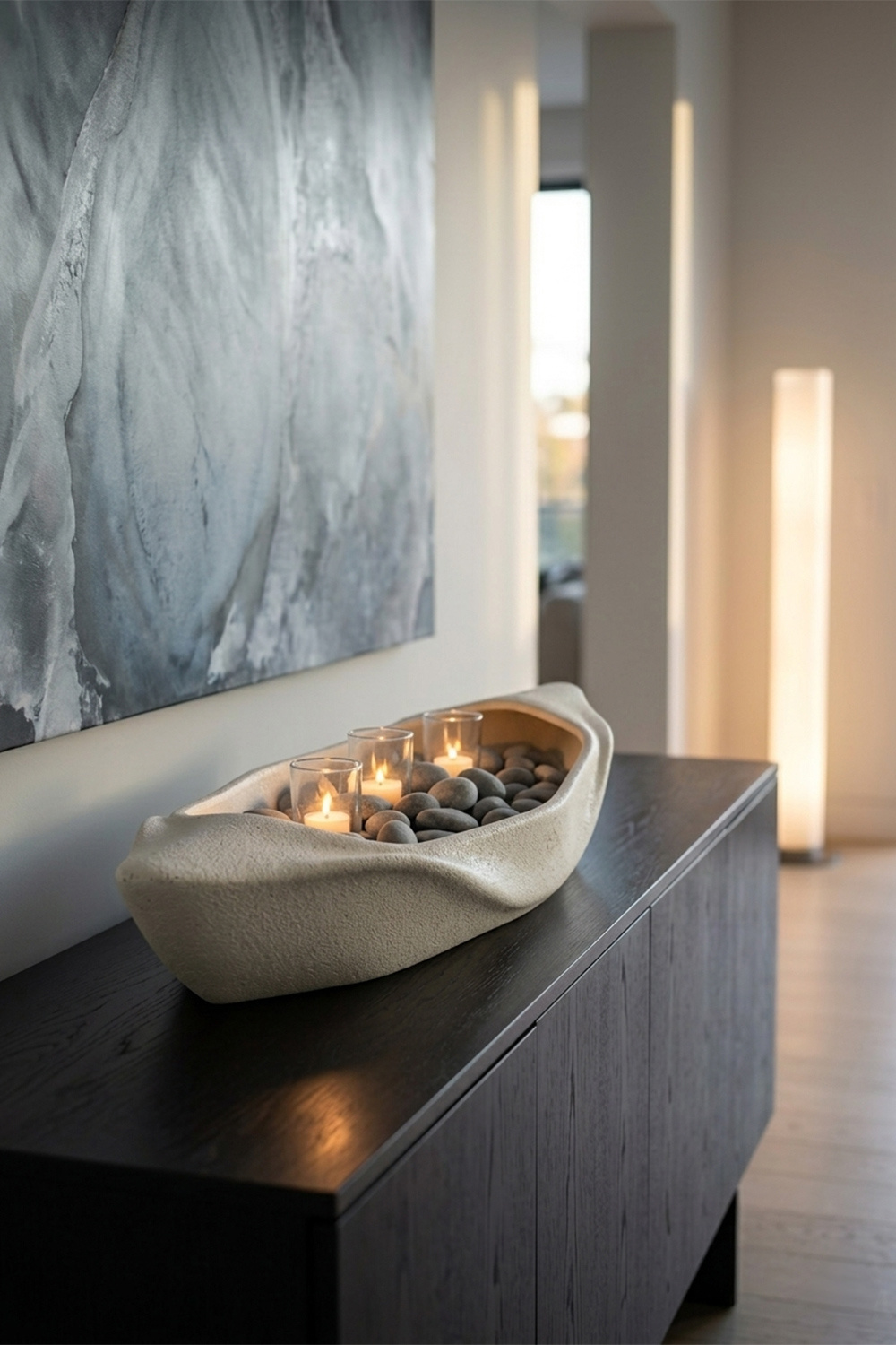 The Dhow Sculptural Centerpiece - Teroli Design Sydney Close-up of the Dhow sculptural mineral stone centerpiece by Teroli Design, featuring organic curves and lit tea light candles among river stones, styled on a dark timber sideboard in a minimalist interior.